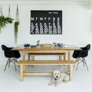room with wooden table and black calendar on wall