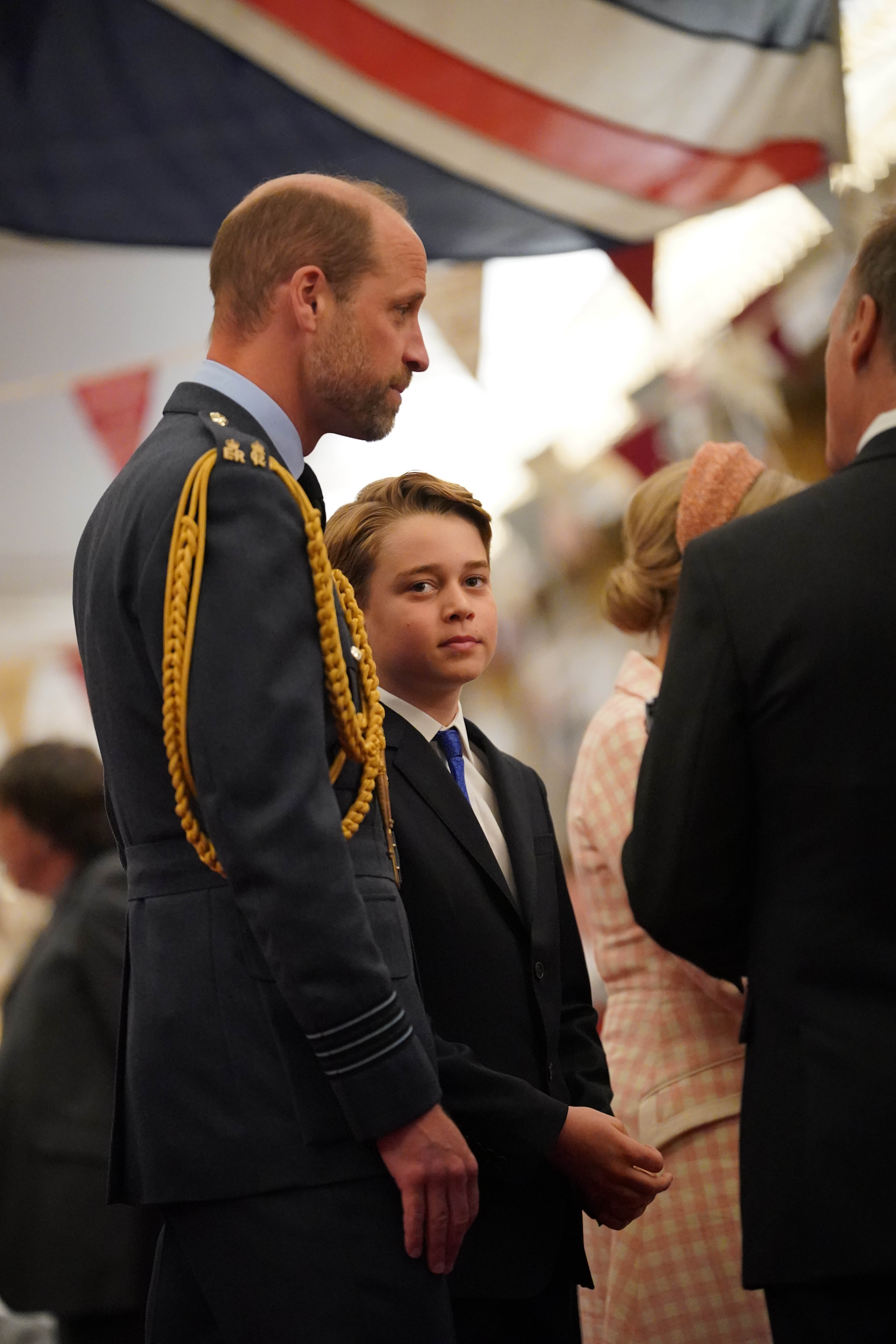 Prince William and Prince George standing under a Union Jack flag