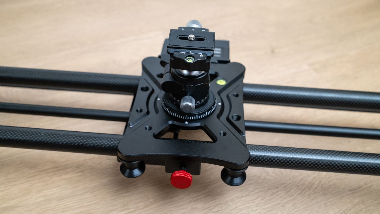 Close up of the central column of a Neewer ER1 Motorized Carbon Fiber Camera Slider on a wooden surface