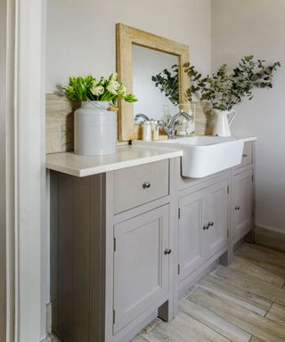 bathroom with flower vase on grey cabinet and mirror