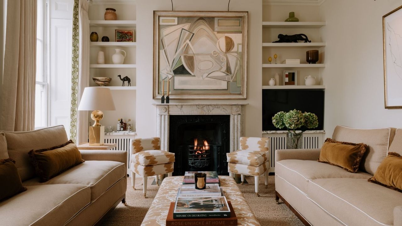 Minimalist living room in neutral colours with a marble fireplace and statement artwork