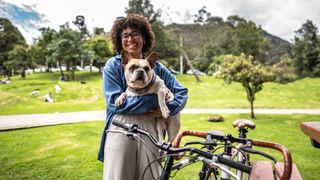 Young woman holding dog in her arms at the park