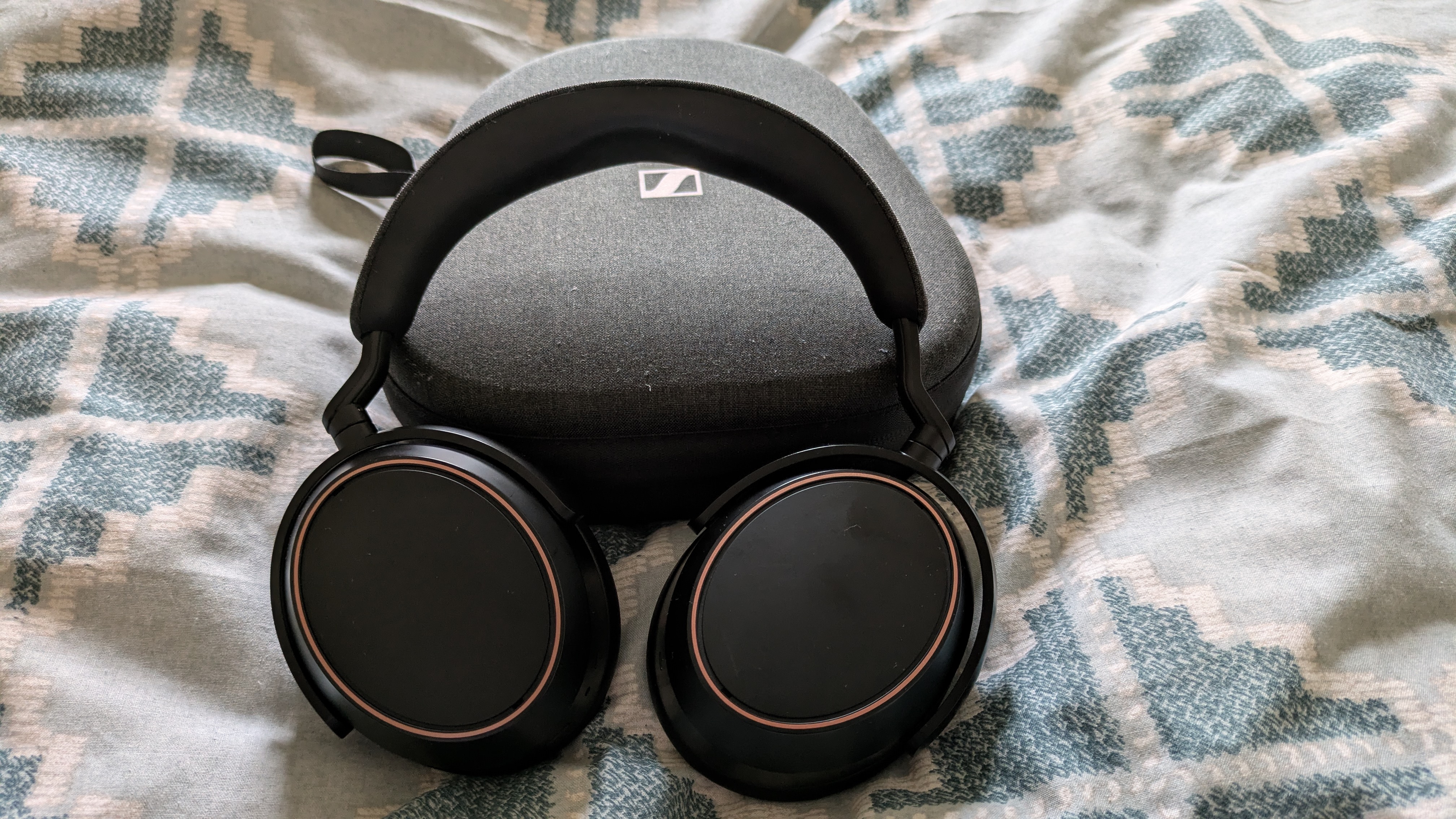 Sennheiser Momentum 4 wireless headphones with case on geometric pattern sheet