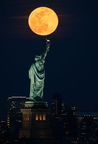 The Super Worm Moon rises above the Statue of Liberty in New York City, on March 9, 2020. 