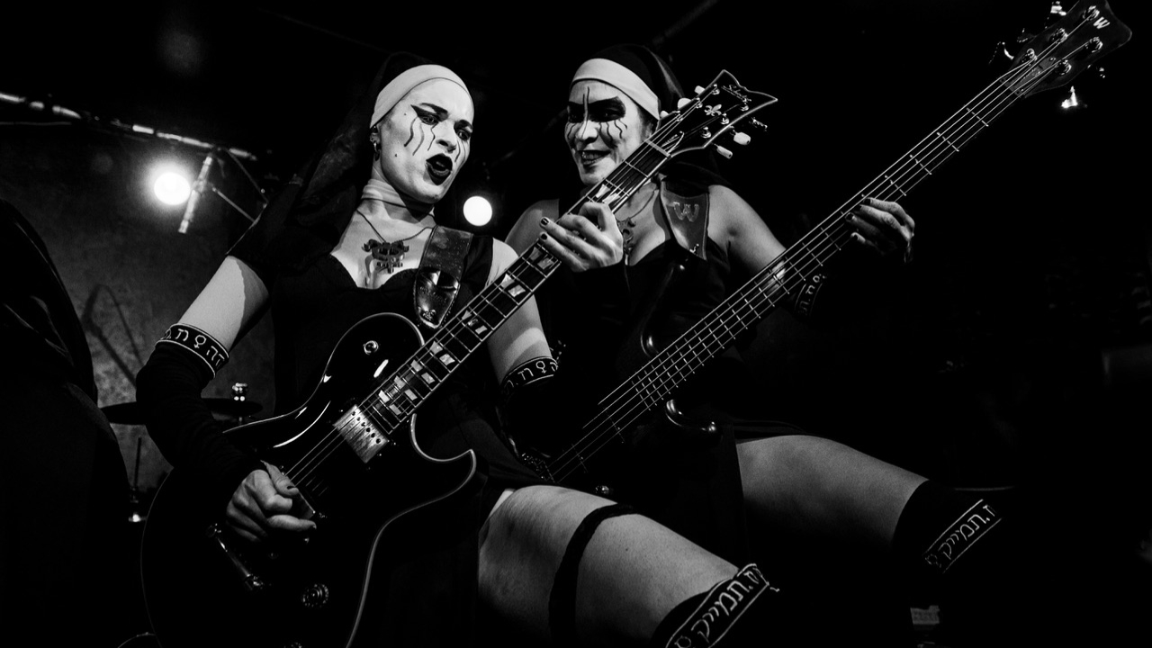 Dogma on stage holding up their guitars