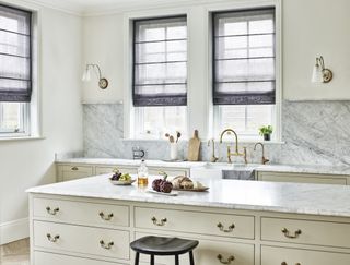 white traditional kitchen with gray linen blinds and brass hardware