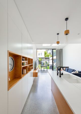 Floor to ceiling kitchen cabinets in a white and oak colored kitchen