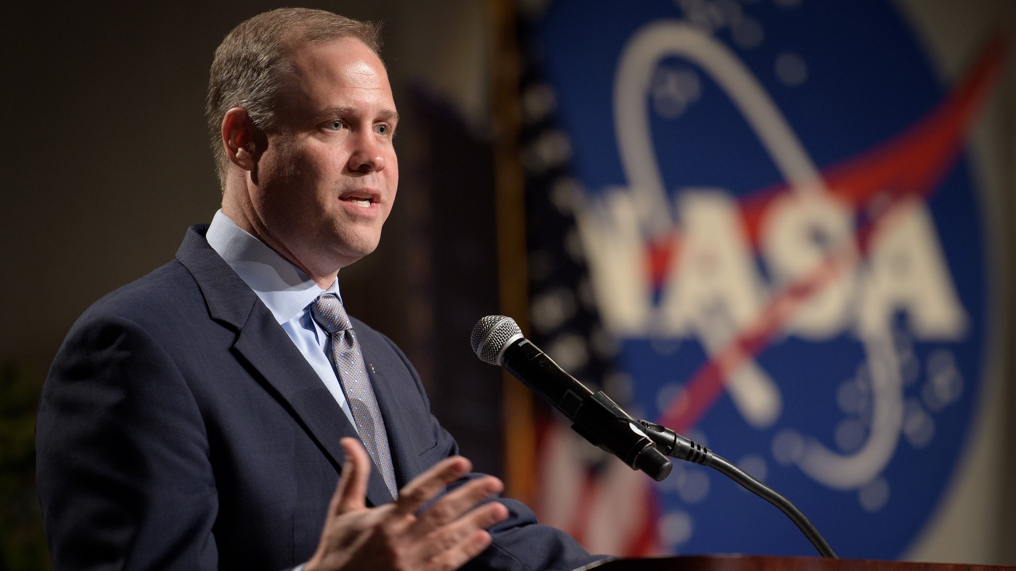 former nasa administrator jim bridenstine at a podium with the nasa logo in behind