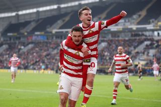 Luke Molyneux of Doncaster Rovers celebrates scoring his team's first goal with teammate Joe Sbarra of Doncaster Rovers during the Emirates FA Cup Third Round match between Hull City and Doncaster Rovers at MKM Stadium on January 12, 2025 in Hull, England.