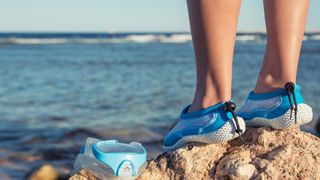 woman wearing aqua shoes at beach