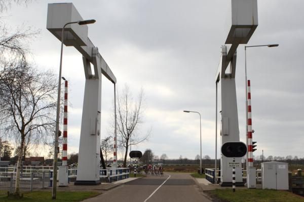 The arrival back in Coevorden, the riders are dwarfed by a bridge