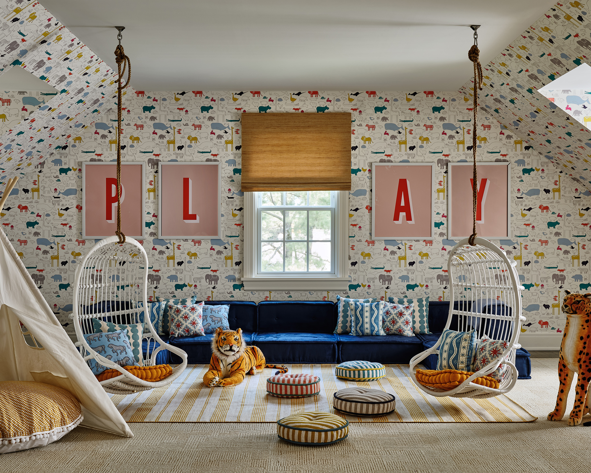 play room with two hanging chairs and the word 'play' framed on the wall