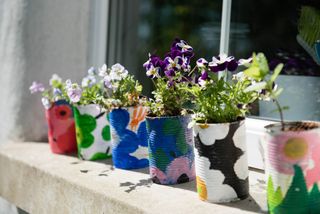painted tins in a garden space for kids