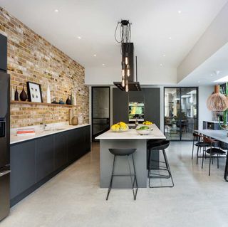 kitchen room with exposed brick wall and kitchen worktop