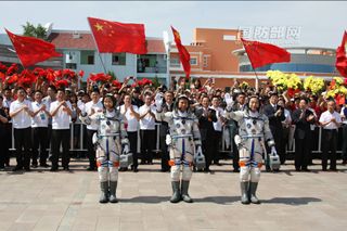 Shenzhou 9 astronaut crew salutes officials on way to launch pad on June 16, 2012.