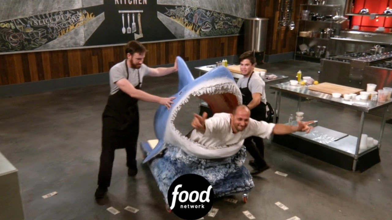 A chef being spun around in a shark head on Cutthroat Kitchen.