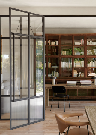 Large metal-framed glass doors with glazed portion separate off a study space