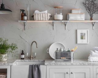 A traditional style laundry room with glass containers to store cleaning products