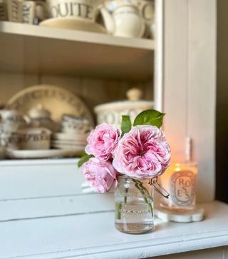 Pink flowers in vase with candle