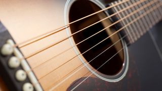 Close up of the steel strings on a Sigma acoustic guitar