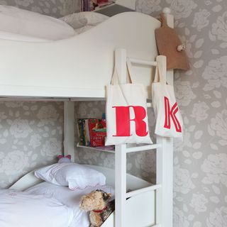 childrens room with floral print wall and rack bed