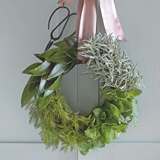 Handmade Christmas wreath with fresh foliage including a selection of leaves and herbs