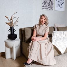 Kathrin Hamm, founder of Bearaby, seated on a couch next to a vase and artwork.