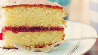 Slice of Victoria sponge cake on plate with fork