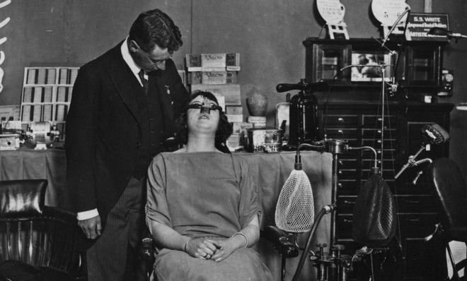 A dentist gives a patient laughing gas in 1922.