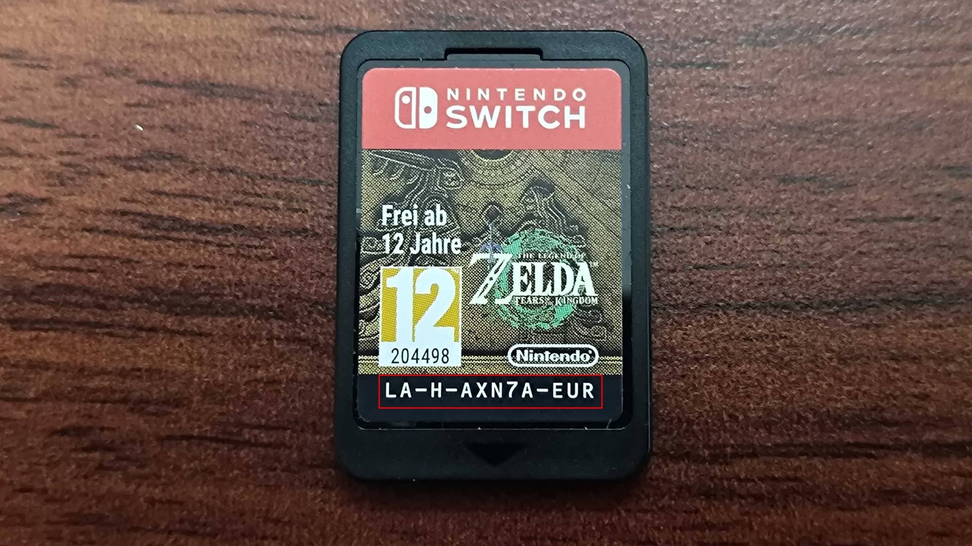 Close up of Zelda: Tears of the Kingdom cartridge with red box around model number on label.