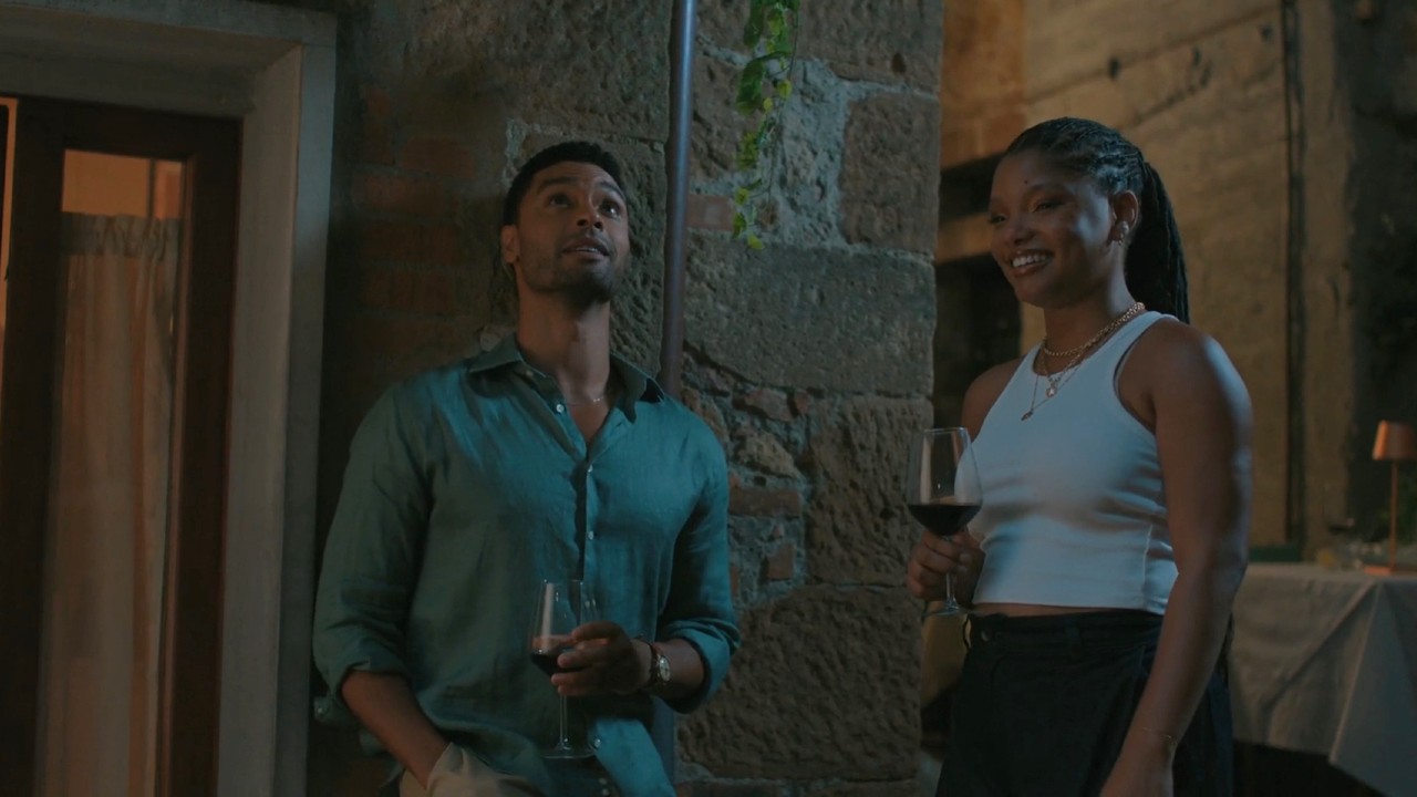 Halle Bailey and Rege Jean Page drinking wine in You, Me, and Tuscany.