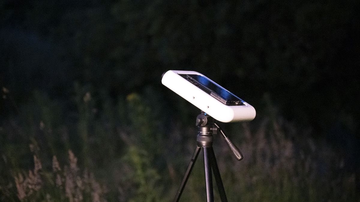 Vaonis Hestia smart telescope on a tripod pointing up at the night sky with a Google Pixel phone attached