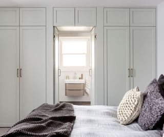 Small bedroom with a hidden door to an en suite set into a run of closets