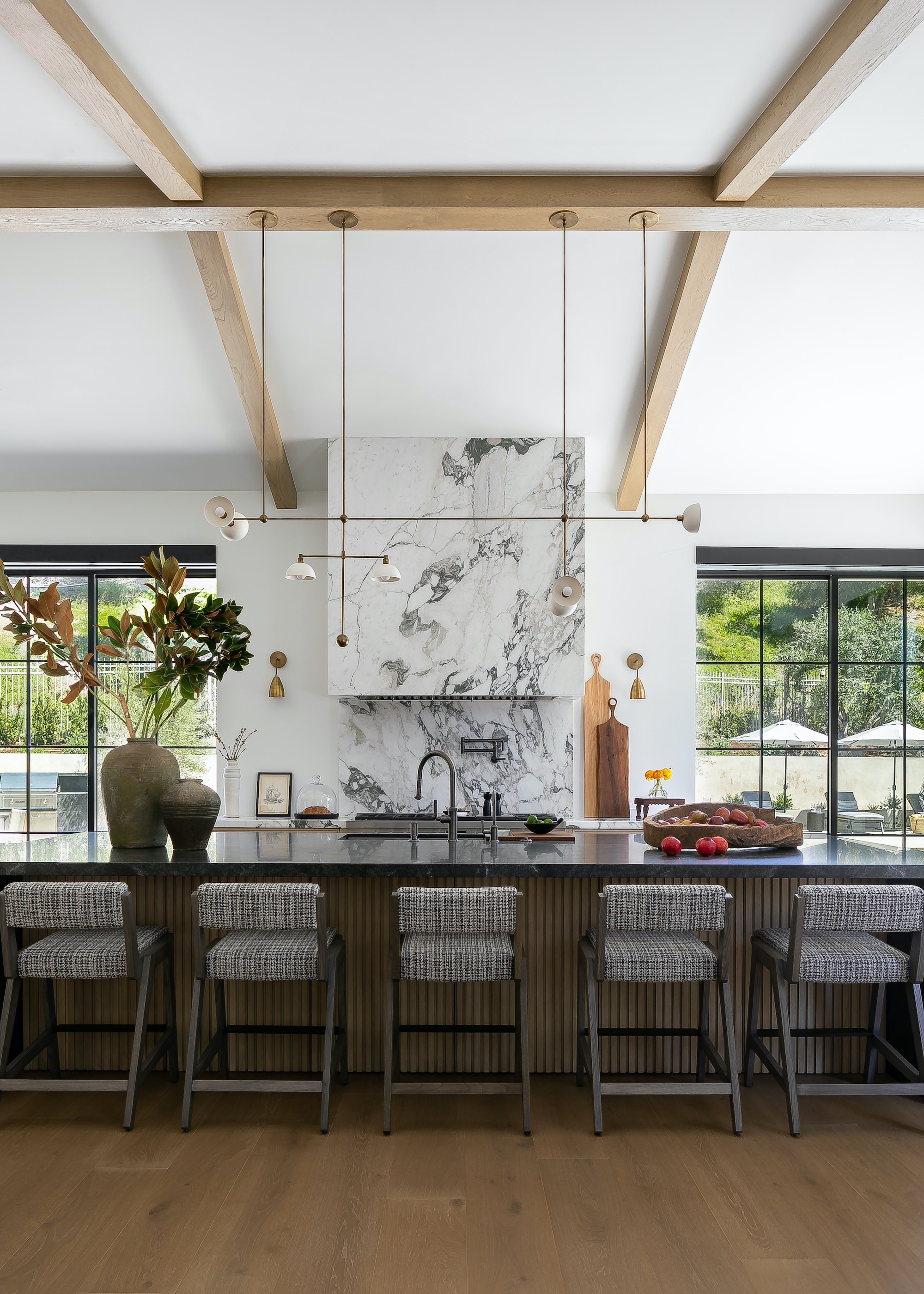 kitchen with marble cooker hood, an oversized island and a row of bar stools