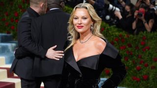Kate Moss on the red carpet in a black dress with a tan
