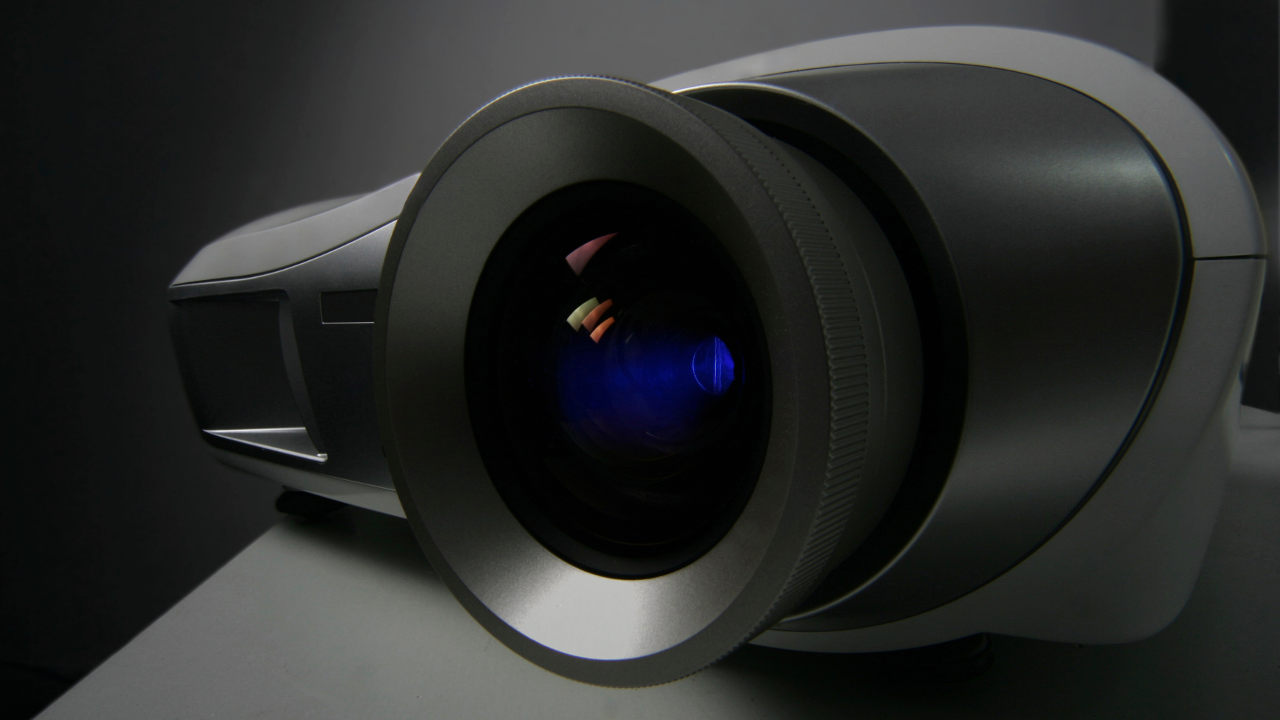 Colored lights reflect in lens of projector