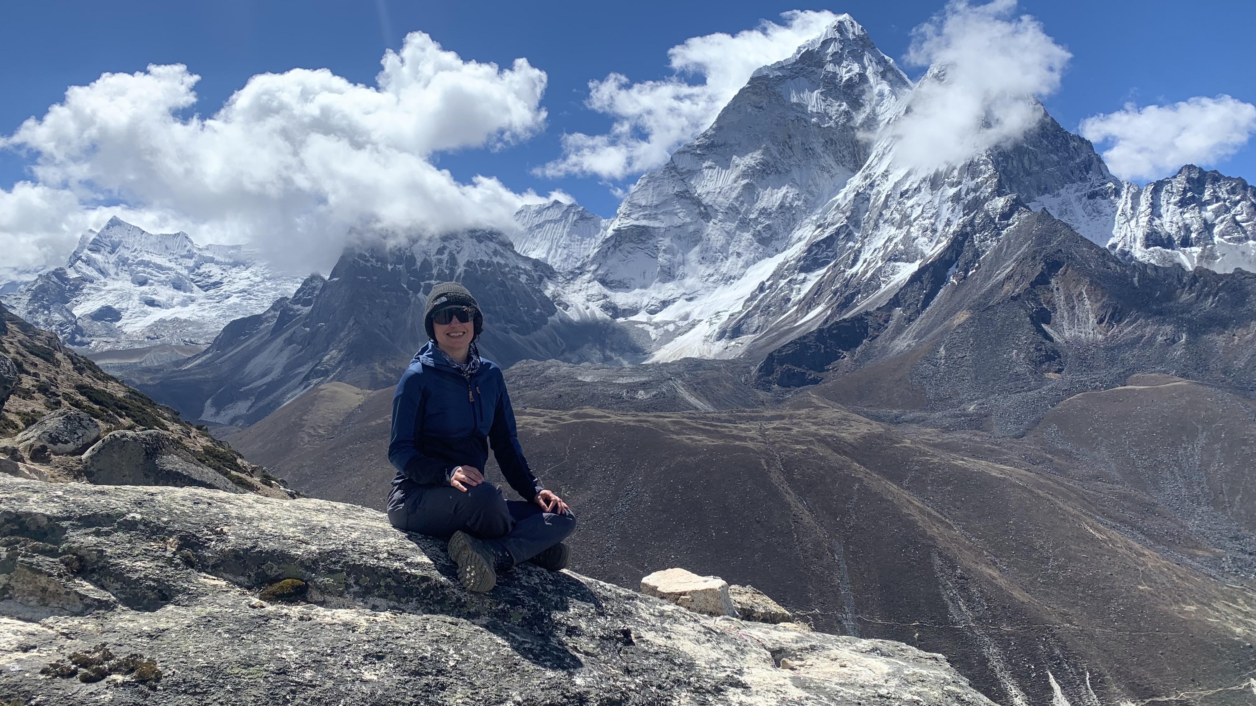 Julia Clarke seated on a rock in the Himalayas
