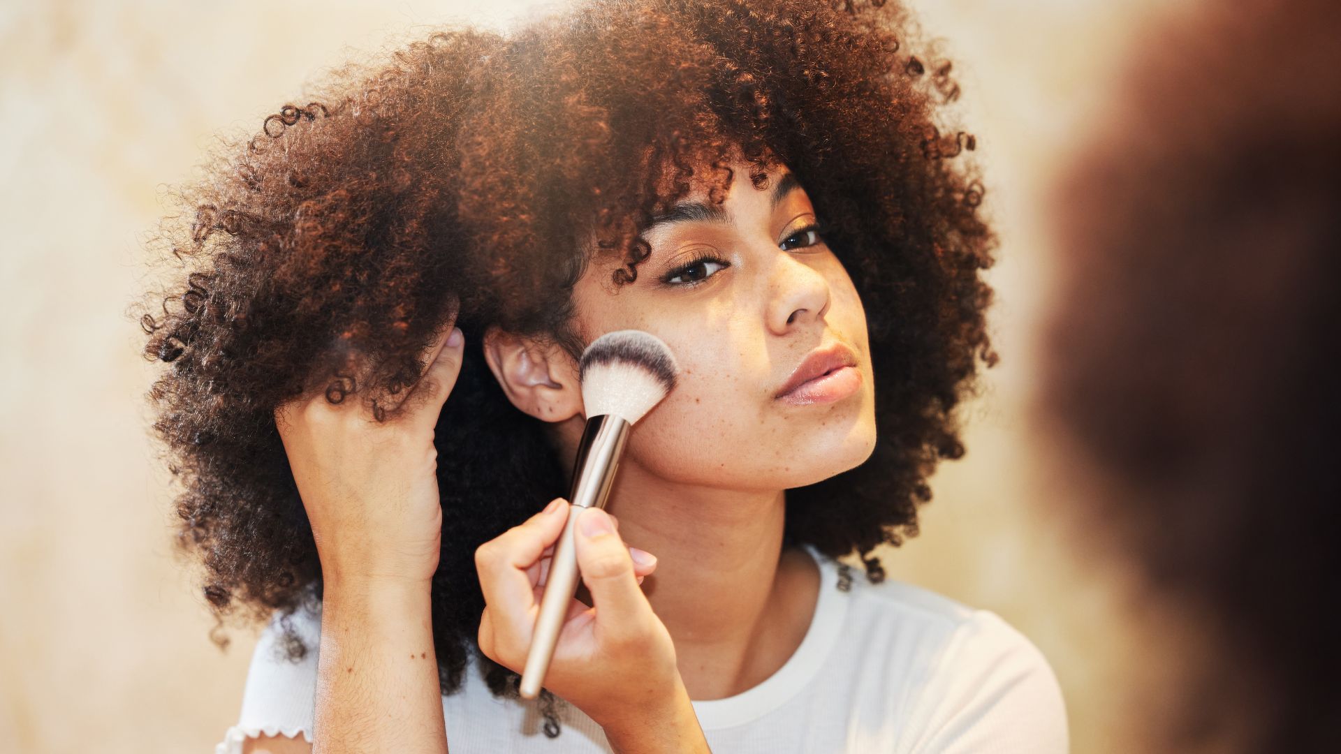 woman applying powder on face