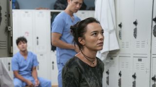 Mika Yasuda (Midori Francis) is shown on Grey's Anatomy with Lucas Adams and Blue Kwan in the background.