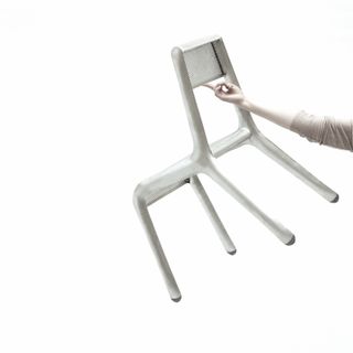 Holding the ultralight recycled aluminium chair with one finger