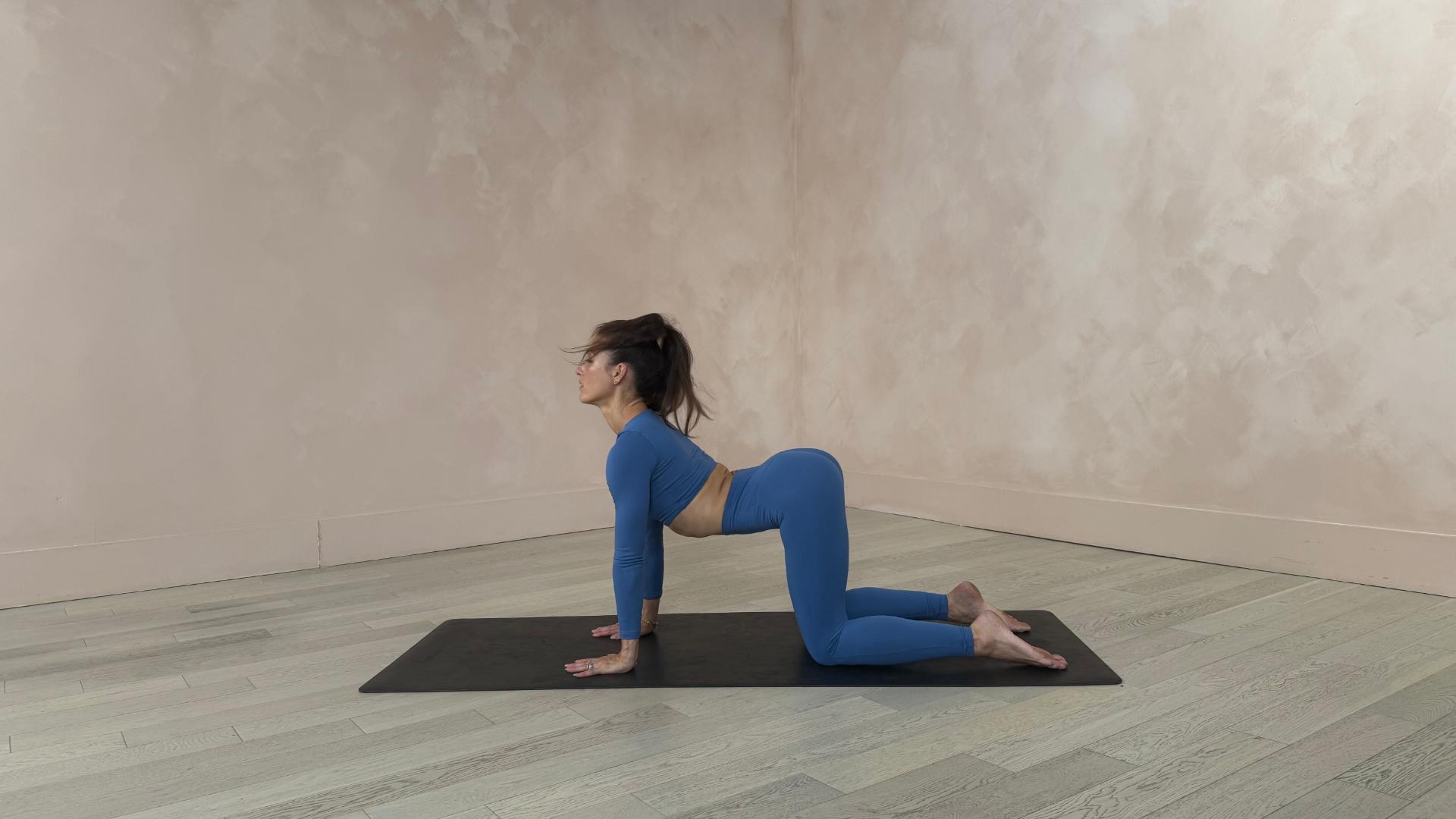woman in the cow of cat cow pose on yoga mat