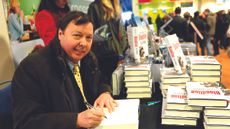 2BAABPG Bloodline author Felix Francis signs copies of his books at Sandown Park.
