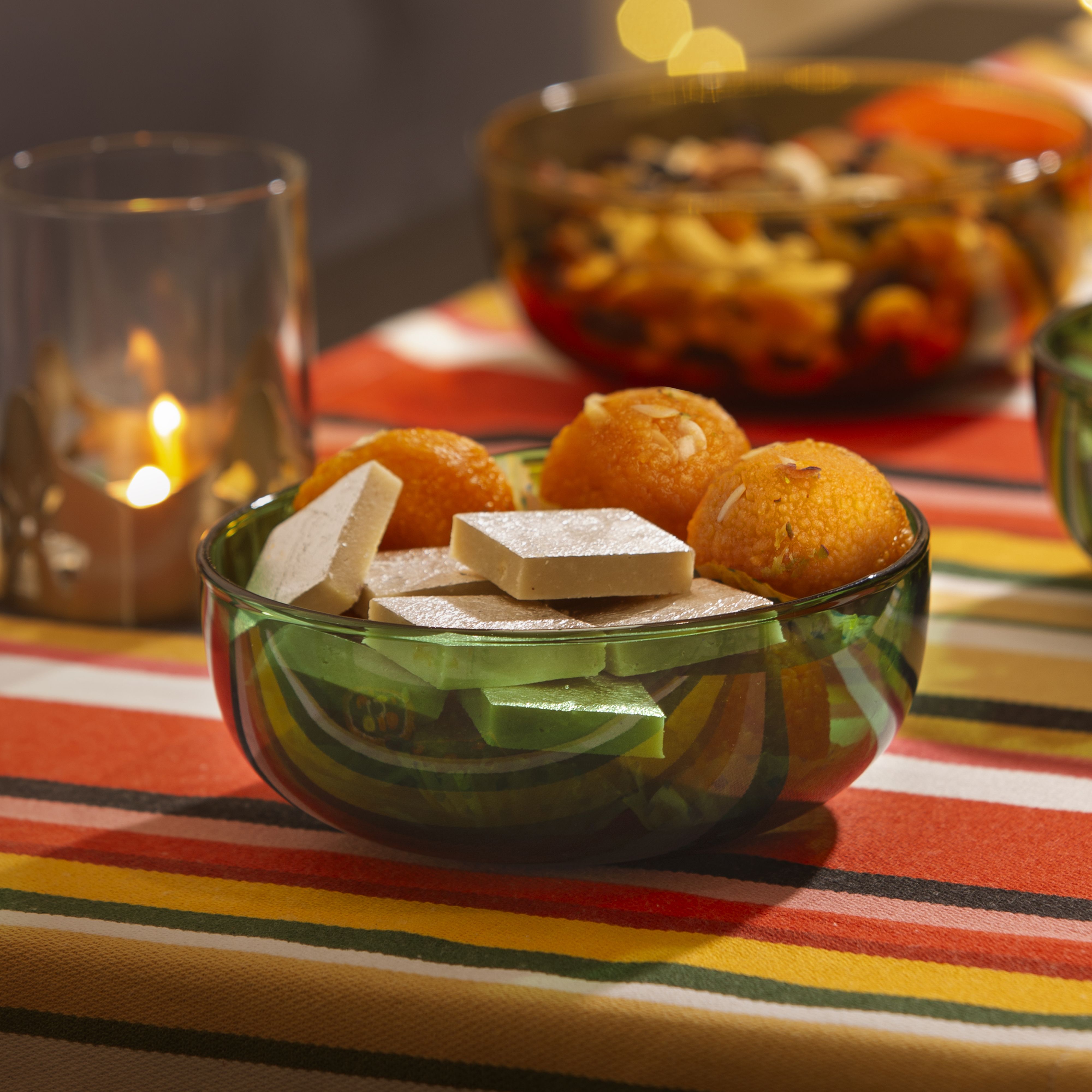 A bowl in green, with mithai in it