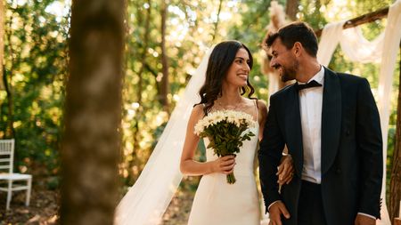Happy newlyweds smiling and walking arm in arm