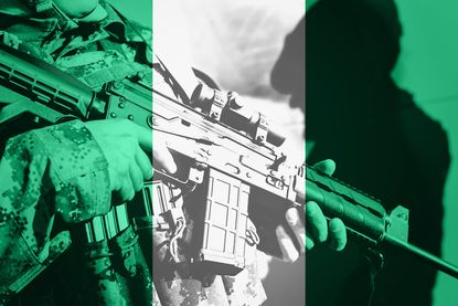 A soldier seen on the background of the Nigerian flag. 
