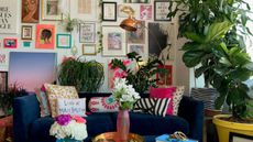 a maximalist livingroom filled with artwork covering the entire wall and a sofa covered in assorted throw pillows