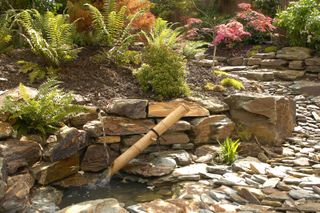 Zen garden ideas: water feature amongst rocks in Japanese-inspired Zen garden