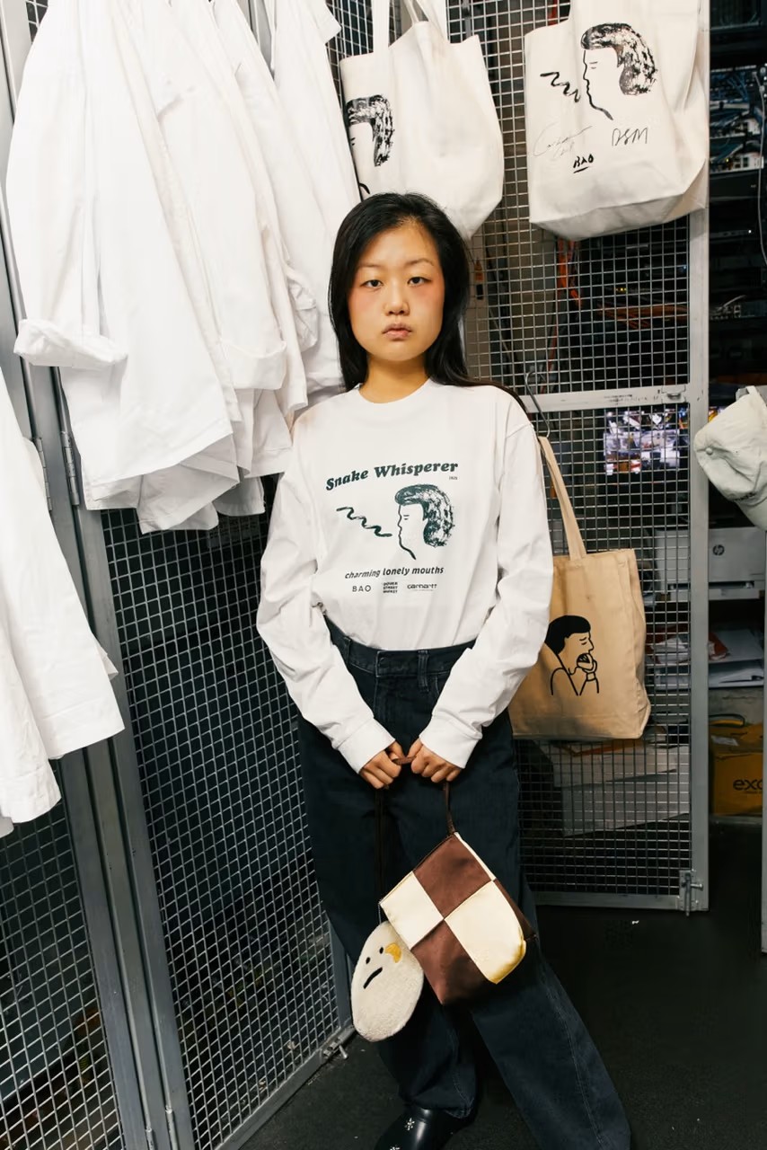 A series of fashion shots of young people wearing restaurant merchandise in white with black logos inside a brightly lit restaurant.