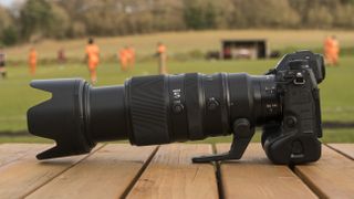 A Nikon Z telephoto lens on a wooden table