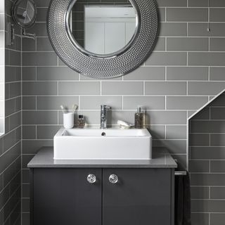 bathroom with white washbasin and grey tiled walls